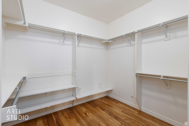 2327 Bluff Ridge Drive Syracuse, UT 84075 - Photo 26 of 66 Spacious walk-in closet featuring wood-finish flooring, white walls, multiple shelving units, and metal hanging rods