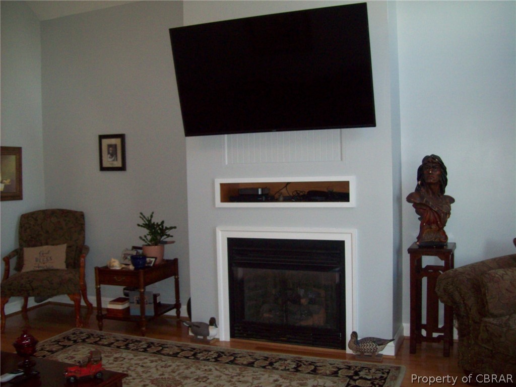 672 Lillys Neck Road Moon, VA 23119 - Photo 27 of 49 a living room with furniture a flat screen tv and a fireplace
