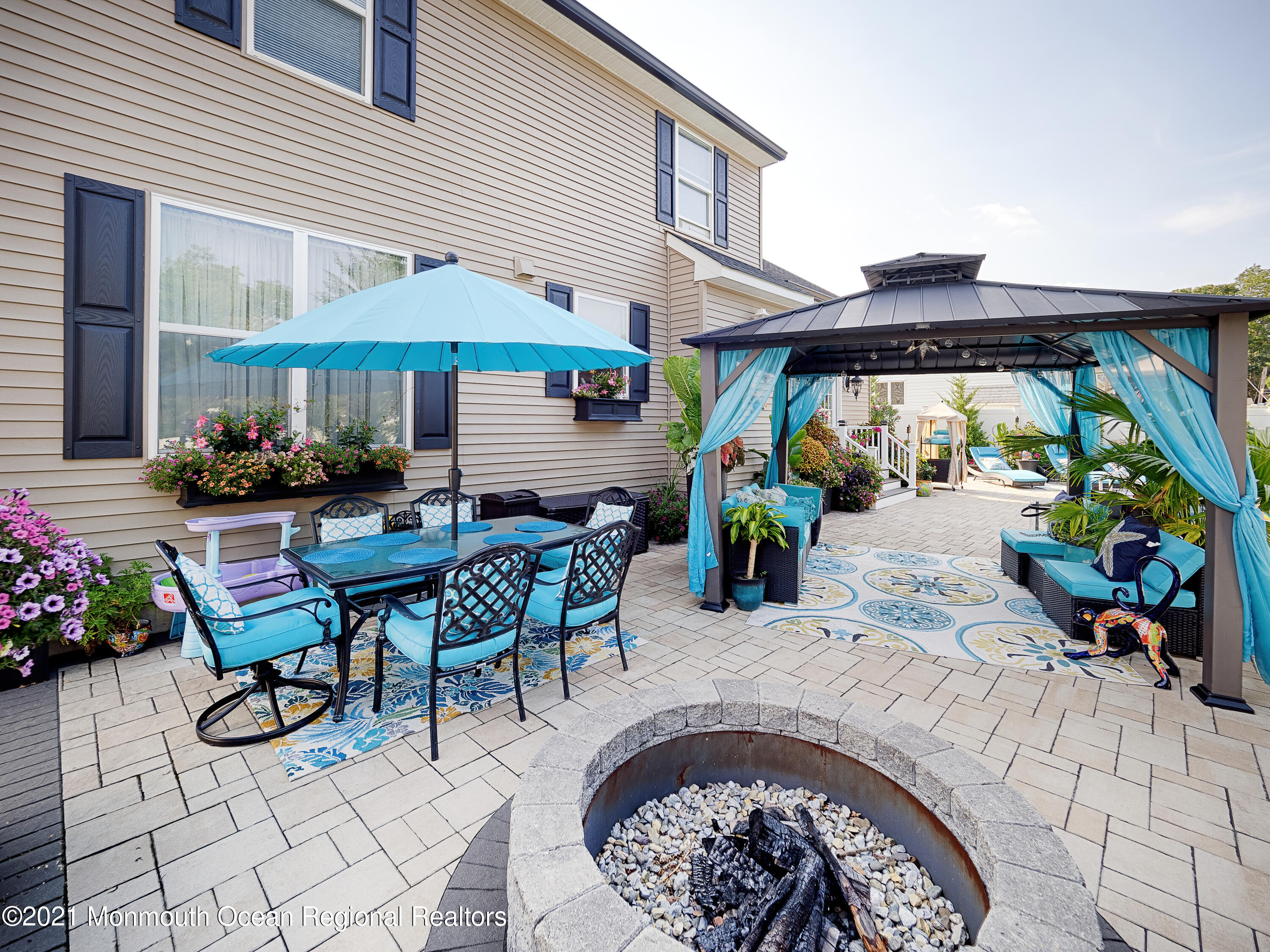 241 Privateer Road Manahawkin, NJ 08050 - Photo 20 of 44 a view of a patio with table and chairs under an umbrella