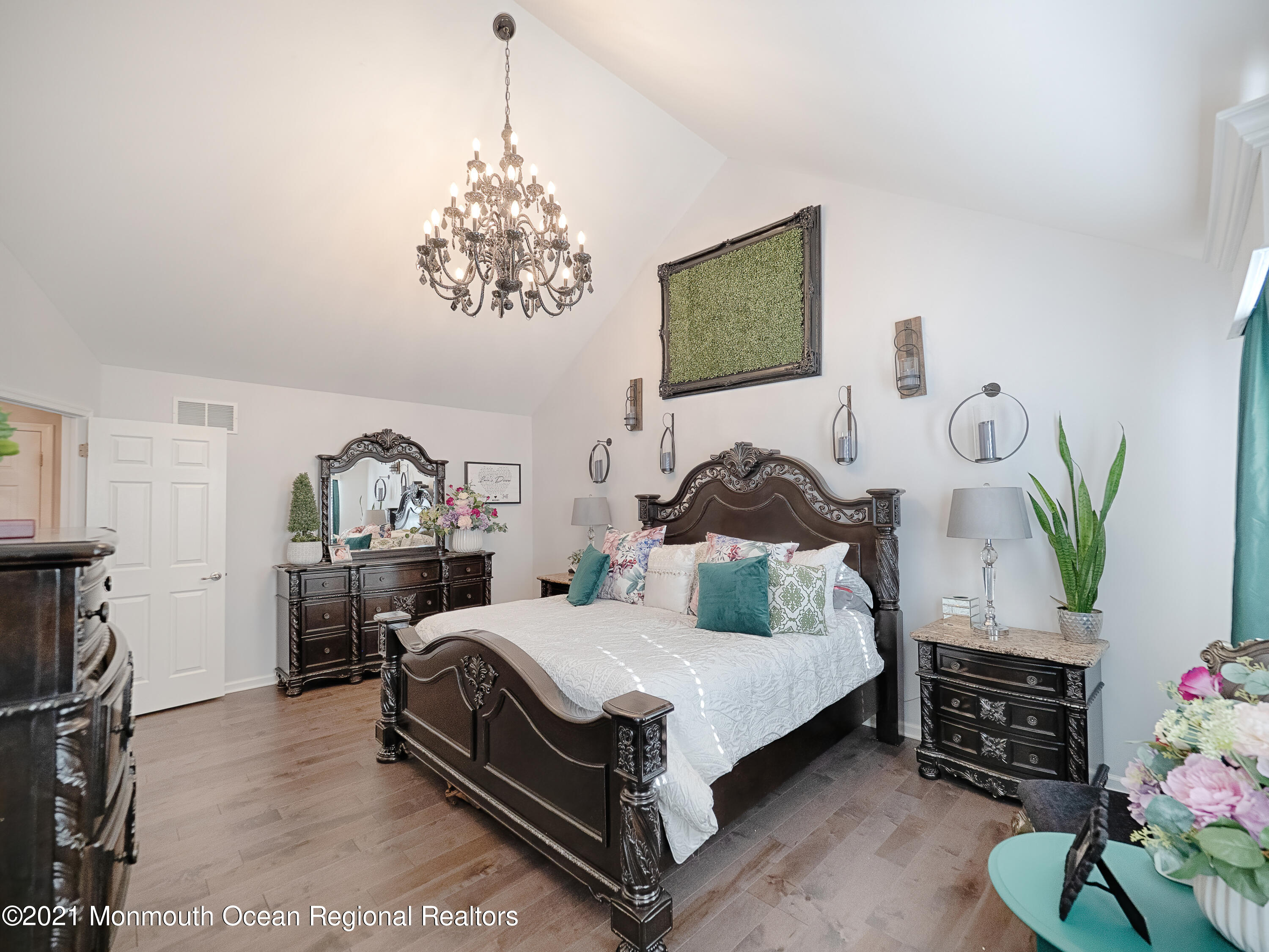 241 Privateer Road Manahawkin, NJ 08050 - Photo 35 of 44 a bedroom with a bed and a chandelier