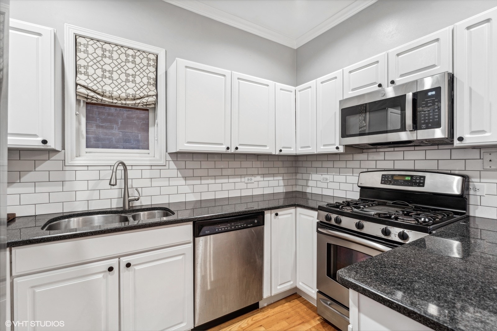 829 West Wolfram Street, Unit 2 Chicago, IL 60657 - Photo 9 of 17 a kitchen with stainless steel appliances granite countertop a sink stove microwave and cabinets