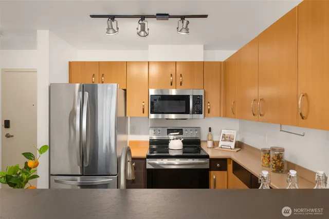a kitchen with stainless steel appliances a refrigerator sink and stove
