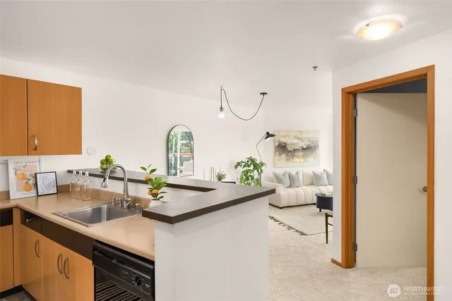 a kitchen with a sink dishwasher and a stove with wooden floor