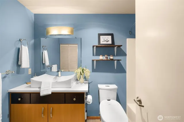 a bathroom with a sink toilet and mirror
