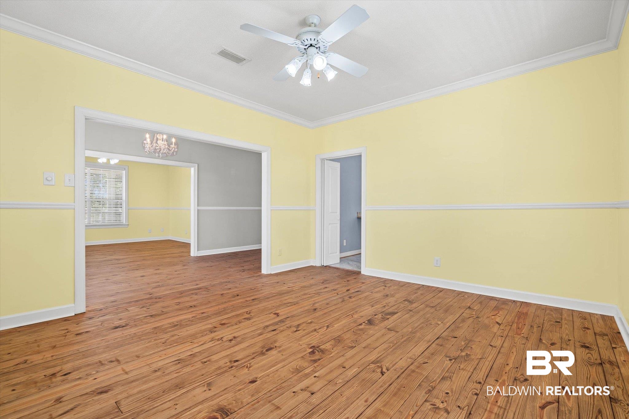 7650 Iron Rush Road Wilmer, AL 36587 - Photo 14 of 34 Spare room with wood-type flooring, a chandelier, ornamental molding, and a ceiling fan