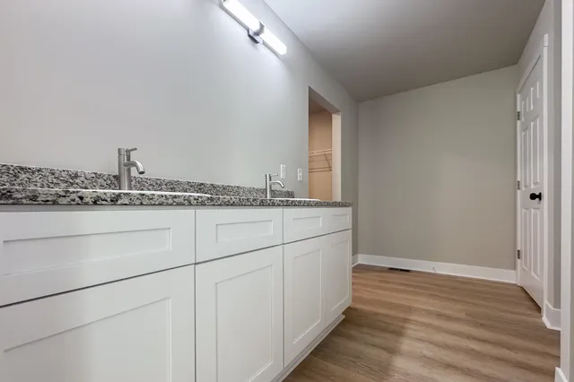 a bathroom with a granite countertop sink and a mirror