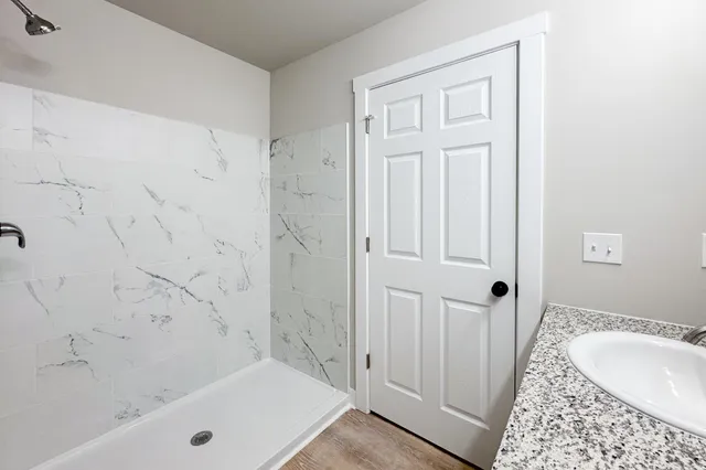 a bathroom with a tub shower and sink