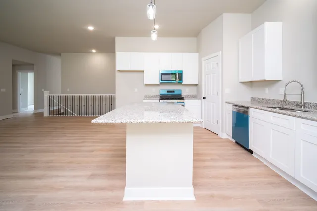 a large kitchen with kitchen island a sink stainless steel appliances and cabinets
