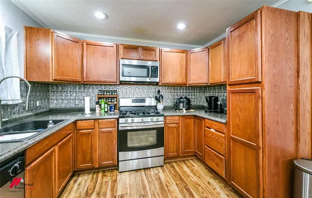 a kitchen with stainless steel appliances granite countertop wooden cabinets a sink and a stove
