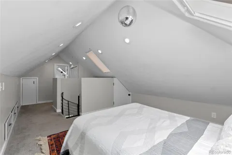 a spacious bedroom with a bed and a chair