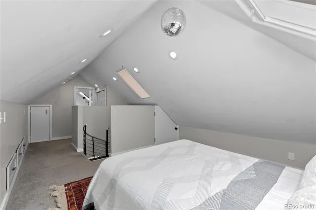 a spacious bedroom with a bed and a chair