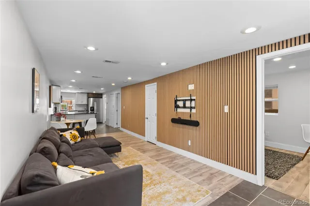 a living room with furniture and a refrigerator