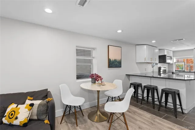 a kitchen with a dining table chairs and a refrigerator a sink