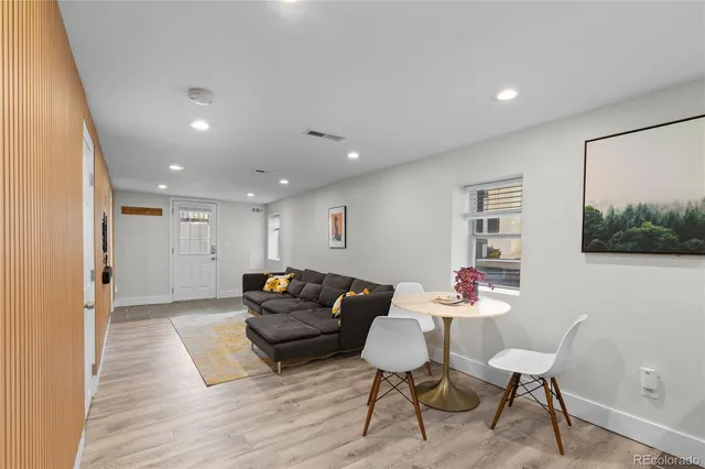 a living room with furniture and a wooden floor