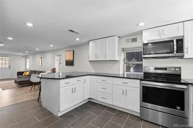 a kitchen with granite countertop a sink and white cabinets