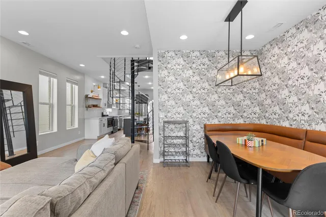 a living room with a table chairs and a kitchen view