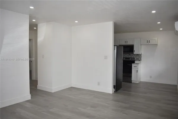 an empty room with wooden floor and entrance
