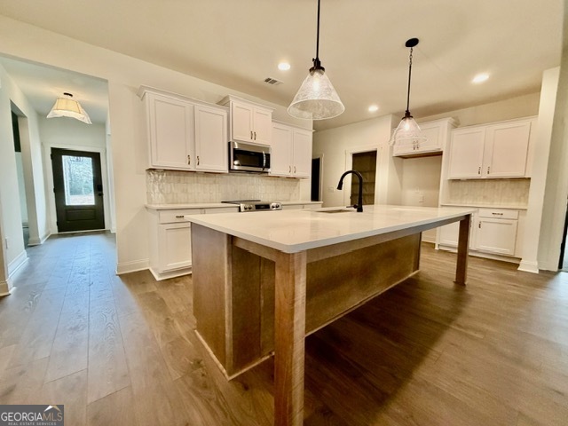 133 Kimbell Road Pine Mountain, GA 31822 - Photo 4 of 17 a large kitchen with kitchen island a stove a sink a refrigerator and a wooden floor