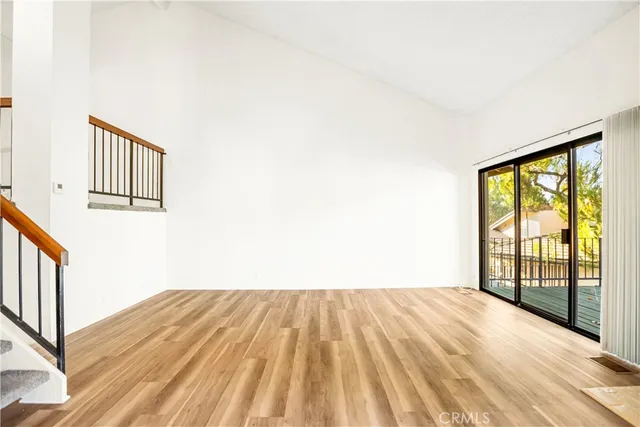 a view of a bedroom with wooden floor and a window