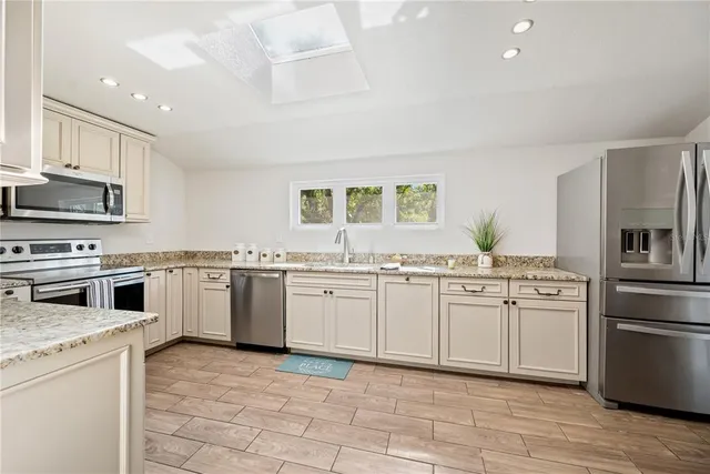 a kitchen with stainless steel appliances granite countertop a stove and a sink