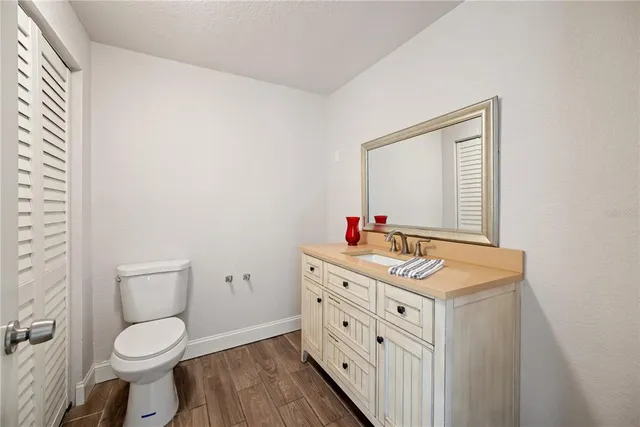 a spacious bathroom with a granite countertop sink a toilet and a mirror