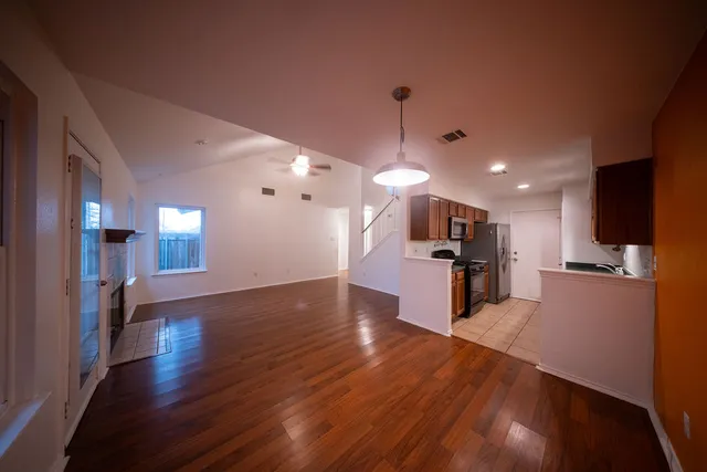 a view of a living room and kitchen with furniture wooden floor