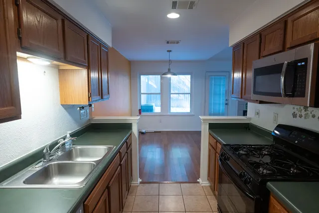 a kitchen with stainless steel appliances granite countertop a sink and a stove