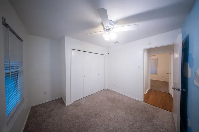 a view of a room that has a chandelier fan and a bathroom