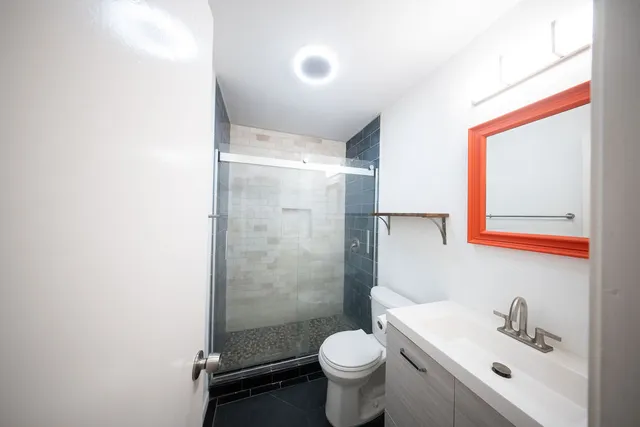 a bathroom with a sink mirror toilet and shower