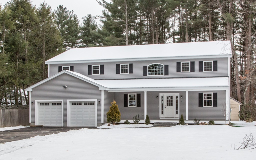 a front view of a house with a tree