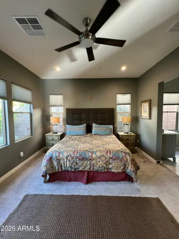 a bedroom with a large bed and windows