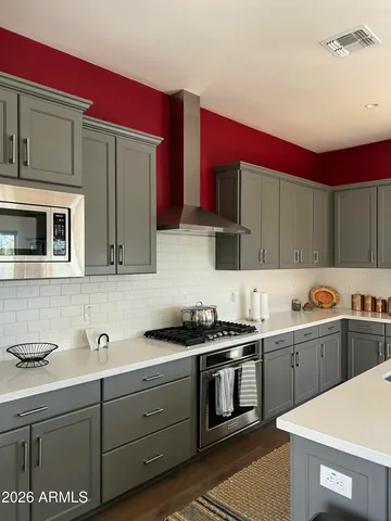 a kitchen with stainless steel appliances a stove a sink cabinets and a microwave