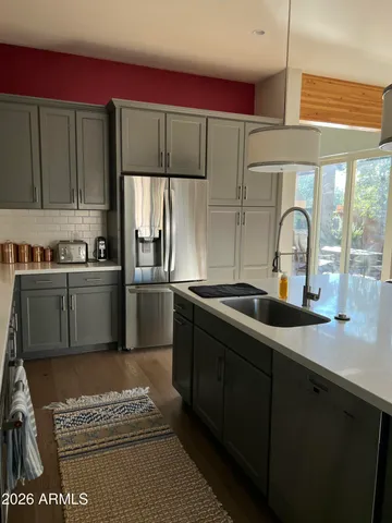 a kitchen with stainless steel appliances a sink cabinets and a refrigerator