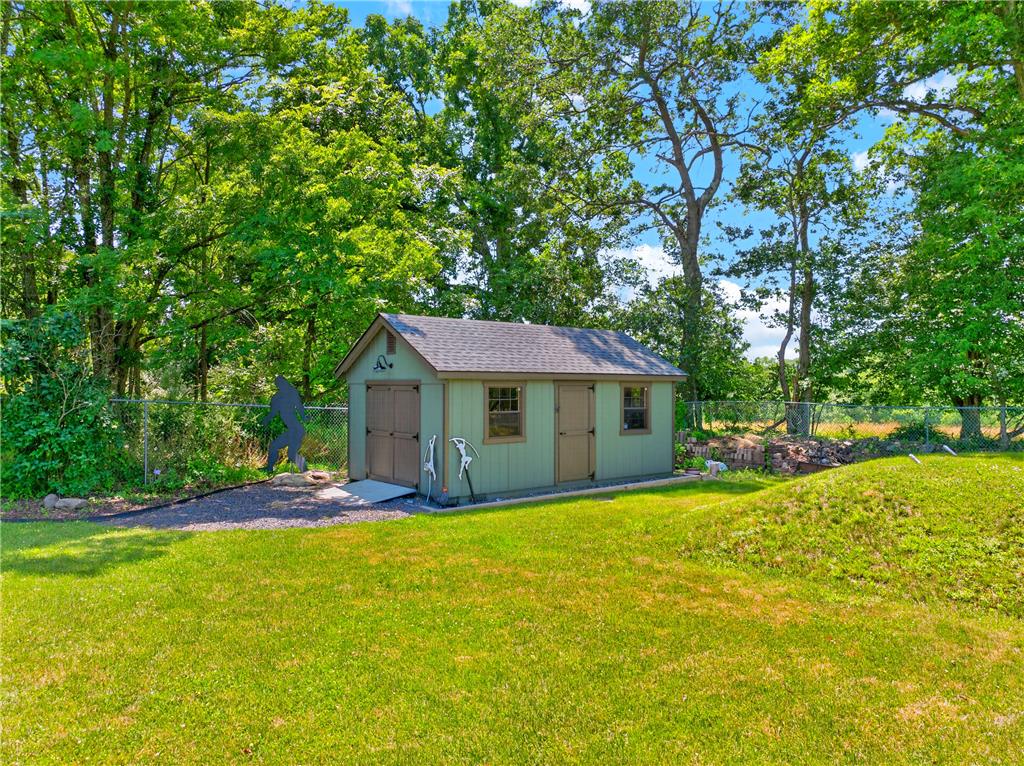 220 Pennbrook Road Stroudsburg, PA 18360 - Photo 57 of 60 A well-maintained shed offers practical storage amidst a verdant, fenced yard.