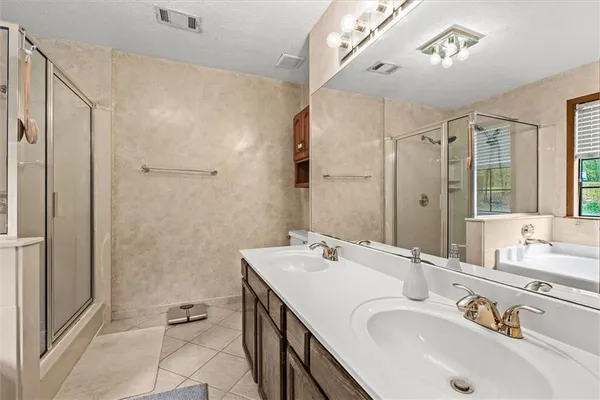 a bathroom with a double vanity sink a mirror and a bathtub
