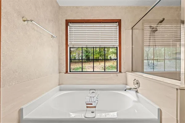 a white bath tub sitting in a bathroom next to a window