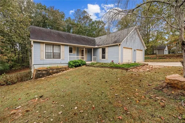 a front view of house with yard and trees around