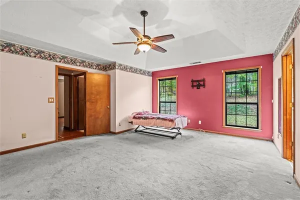an empty room with windows and ceiling fan