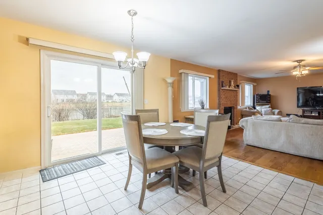 a view of a dining room and livingroom with furniture wooden floor a chandelier