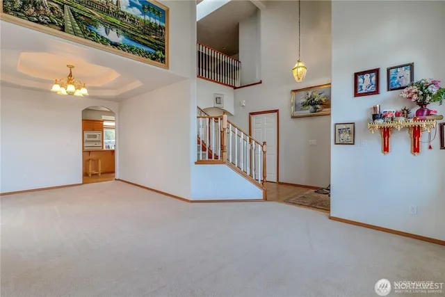an empty room with windows and chandelier