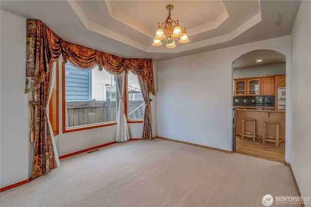 a kitchen with stainless steel appliances wooden floor dining table and chairs