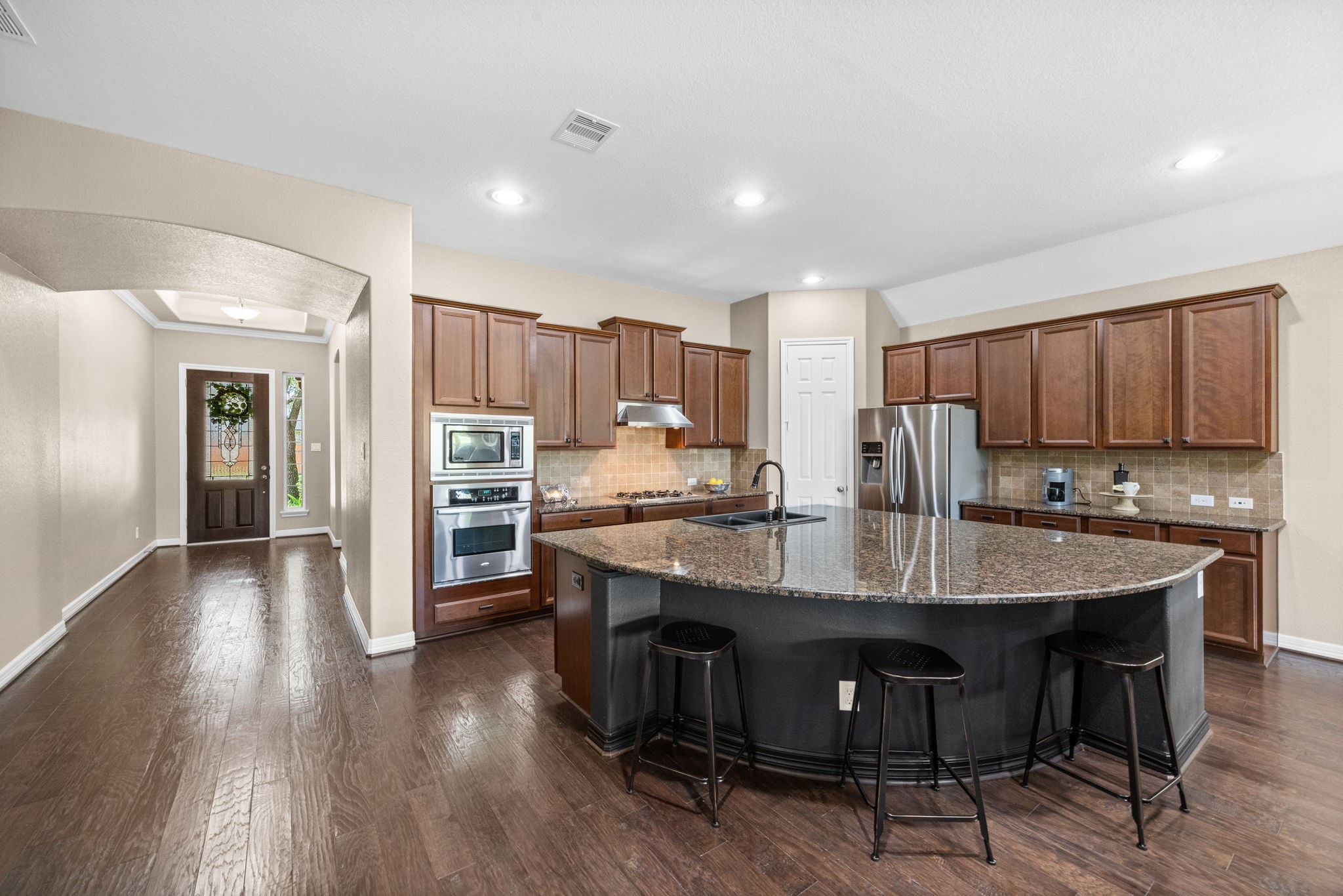 27642 Linden Ridge Lane Fulshear, TX 77441 - Photo 7 of 42 The oversized Kitchen island comfortably seats up to six or more, with seating on both sides, making it the perfect gathering spot for casual meals, entertaining, or visiting with family and friends. The Kitchen is equipped with Whirlpool Gold stainless steel appliances, including a built-in oven, microwave, dishwasher, and a 4-burner gas cooktop, combining style and functionality for the home chef.