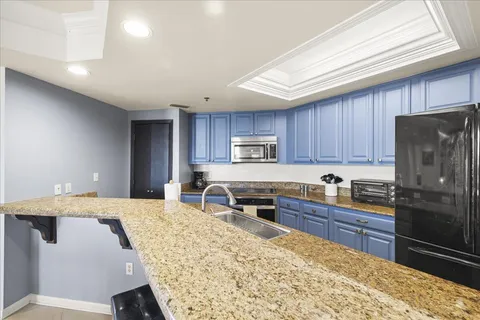 a view of a dining room and livingroom with furniture wooden floor a chandelier