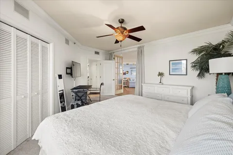 a bedroom with a bed tv and a chandelier
