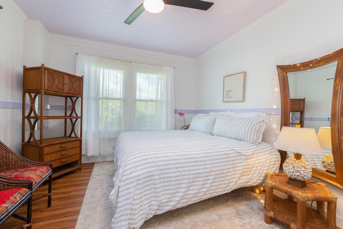 1111 Kealoha Road Kapaa, HI 96746 - Photo 11 of 30 a bedroom with a bed and wooden floor