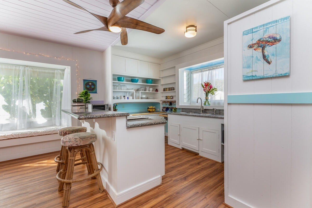 1111 Kealoha Road Kapaa, HI 96746 - Photo 6 of 30 a kitchen with stainless steel appliances granite countertop a refrigerator a sink dishwasher a stove and white countertops with wooden floor
