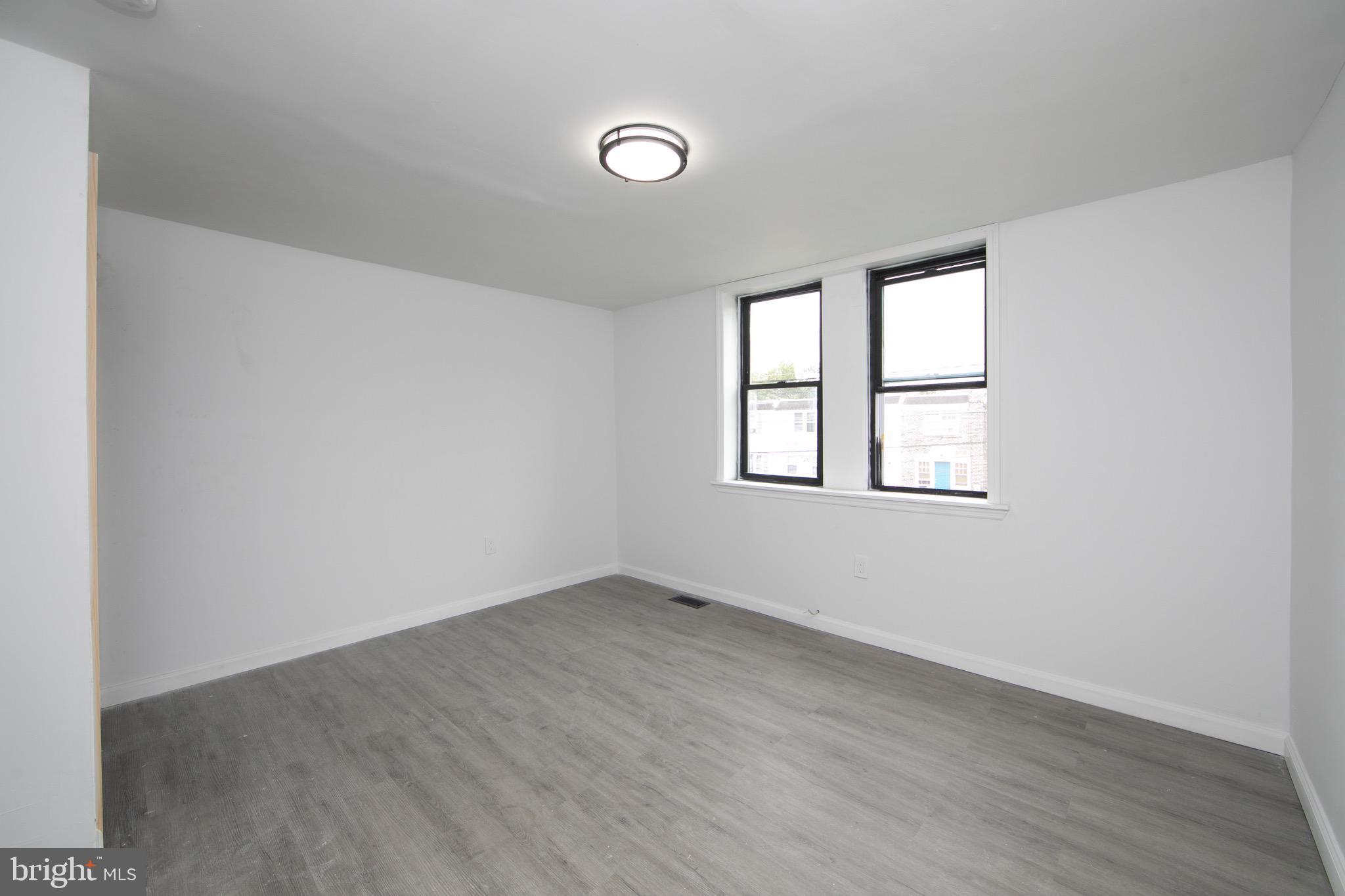 1261 South Merrimac Road Camden, NJ 08104 - Photo 12 of 27 an empty room with wooden floor and windows