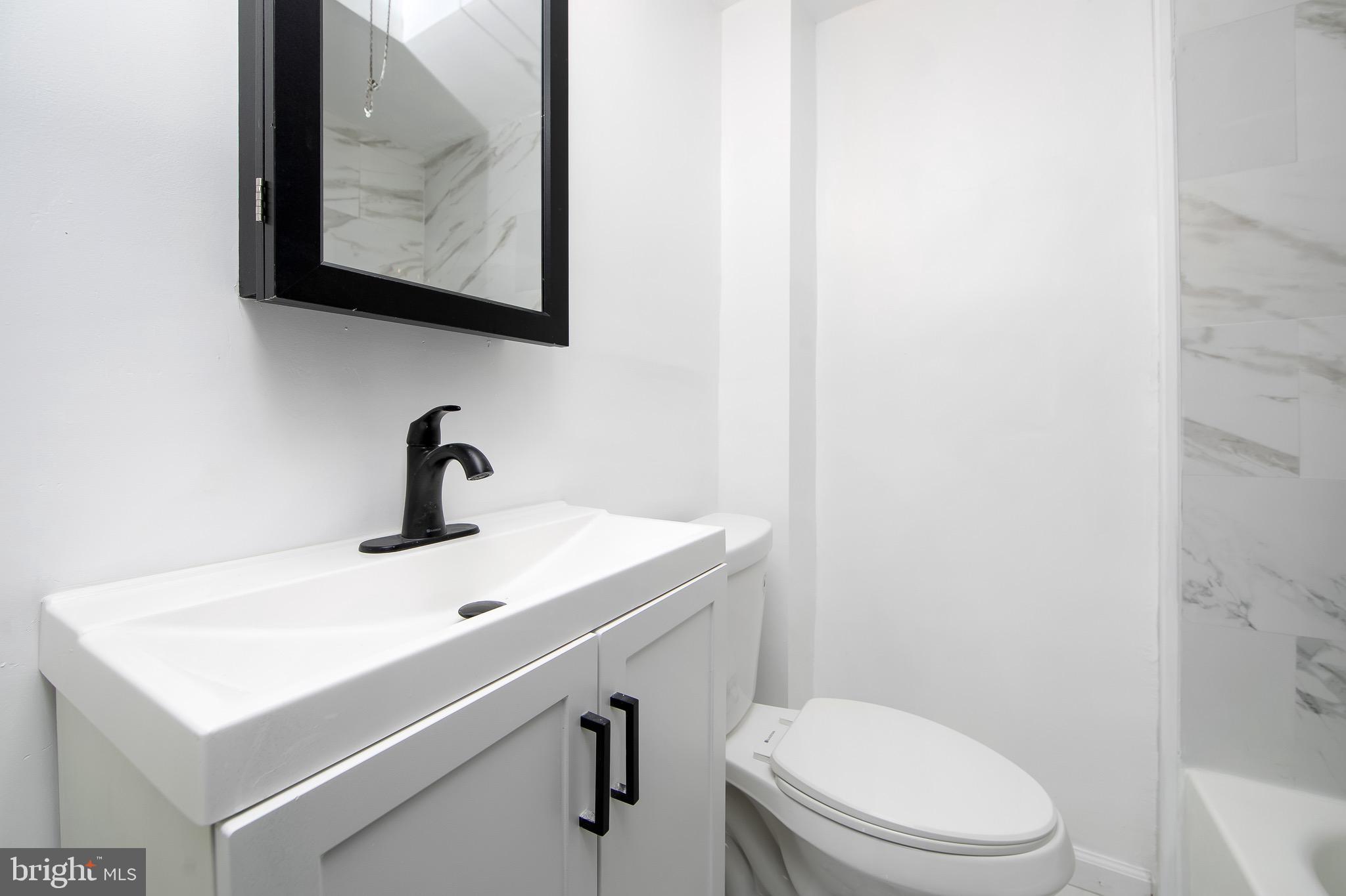 1261 South Merrimac Road Camden, NJ 08104 - Photo 16 of 27 a bathroom with a toilet sink and mirror