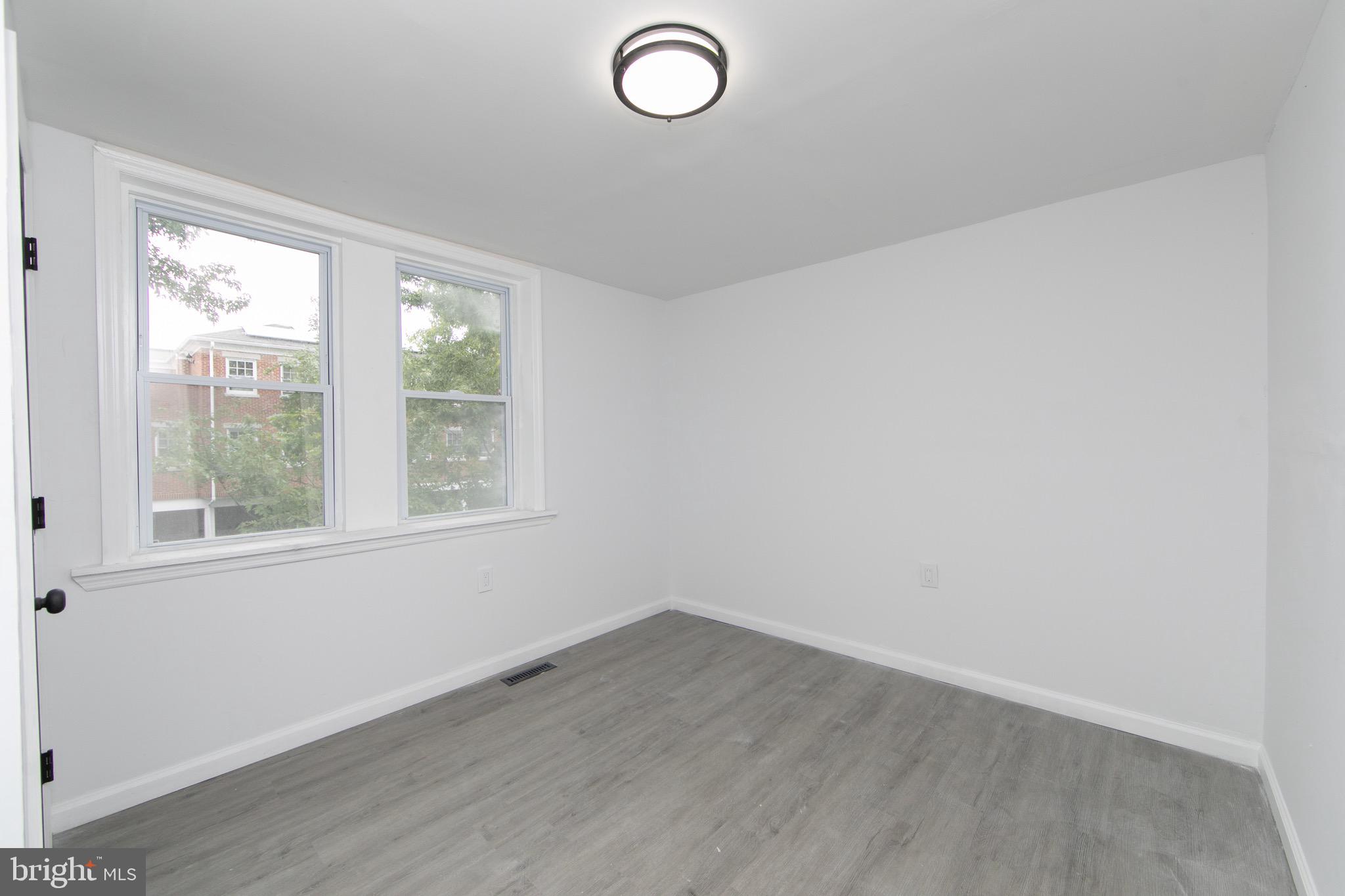 1261 South Merrimac Road Camden, NJ 08104 - Photo 18 of 27 an empty room with wooden floor and windows