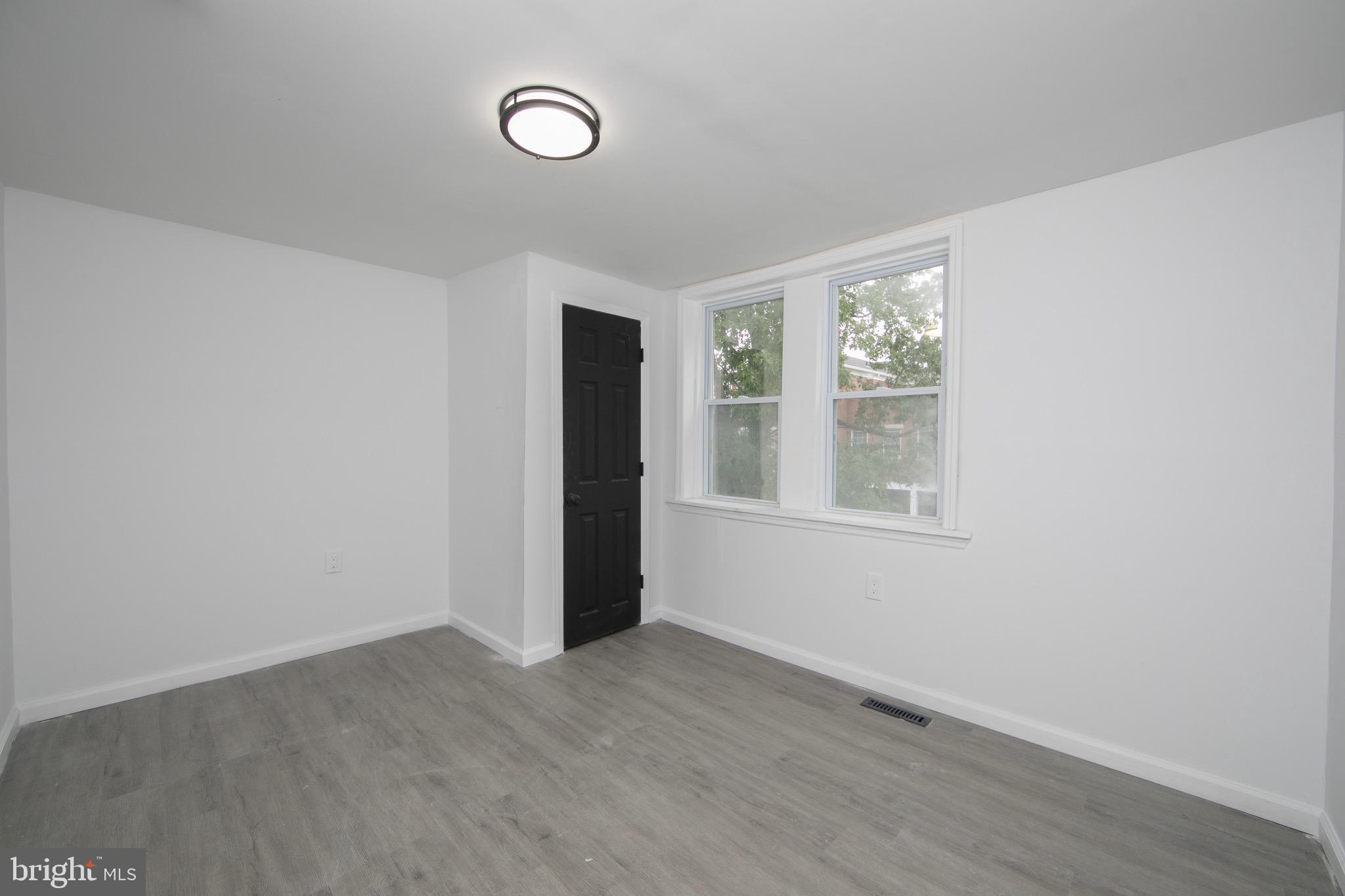 1261 South Merrimac Road Camden, NJ 08104 - Photo 20 of 27 an empty room with wooden floor and windows